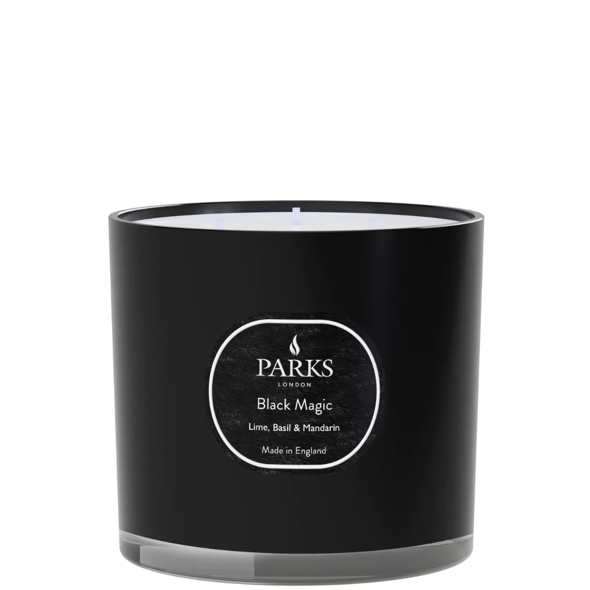 A black candle with a white label that reads 'PARKS Black Magic Lime, Basil & Mandarin', indicating the fragrance of the candle.