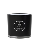 A black candle with a white label that reads 'PARKS Black Magic Lime, Basil & Mandarin', indicating the fragrance of the candle.
