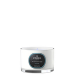 A white travel-sized candle with a label that reads 'PARKS Aromatherapy Linen Fresh' in a clear glass vessel with a silver base.