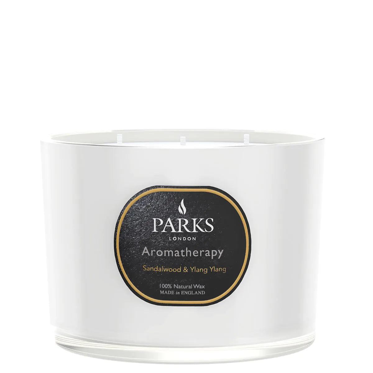 A white, glass vessel candle with a label that reads 'PARKS Aromatherapy Sandalwood & Ylang Ylang'. The candle is unlit and appears to be a luxury product.