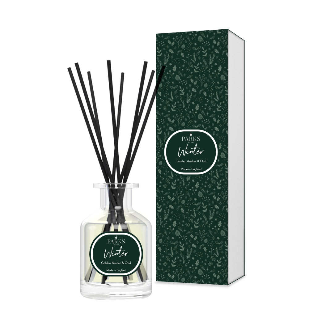 Diffuser bottle with black sticks and green packaging on a white background