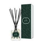 Diffuser bottle with black sticks and green packaging on a white background