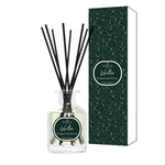 Diffuser bottle with black sticks and green packaging on a white background