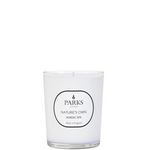 A white candle with a label that reads 'PARKS NATURE'S OWN NORDIC SPA'. The candle is unlit and has a clean, simple design with a clear glass enclosure.