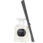 A clear glass diffuser bottle with black reeds, labeled 'PARKS Aromatherapy', containing a yellowish liquid.